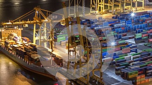 Seaport and loading docks at the port with cranes and multi-colored cargo containers night timelapse