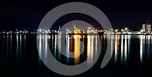 Seaport night view with colorful reflection in water