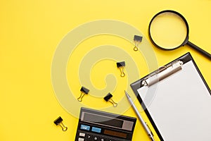 Search or choose a job. Career or office desk concept. Office supplies, blank and magnifier on a yellow background