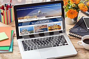 Search flights on a computer laptop screen, office desk background