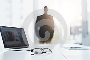 In search of greater opportunities for business. Closeup shot of a pair of spectacles and a laptop on a table in an