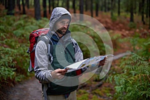 Search, map and man lost in forest with guide to camp in woods or thinking of navigation or direction. Confused, travel