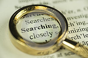 Searching Concept With Closeup Golden Magnifying Glass photo