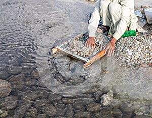 Searching for emeralds in soil of the Swat emerald mine near the excavation site in the swat rive, Pakistan