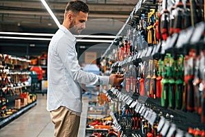 Searching for the tools. Man is in the hardware shop