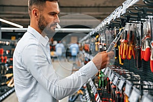 Searching for the tools. Man is in the hardware shop