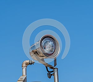 Searchlight mounted on metal pole