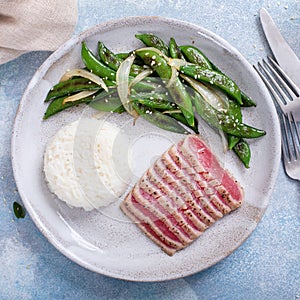 Seared tuna steak with white rice and green peas