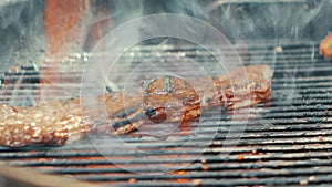 searing beef short ribs over a red hot grill outside close up