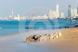 Seasacpe consist of rock on the Pattaya beach with Pattaya city as background  Use long Exposure technic therefore Fuzzy blue sea