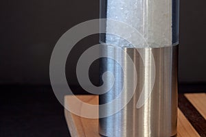 Seasalt grinder,on black background,selective focus, photo