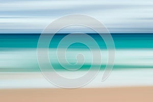 A seascape abstract with panning motion combined with a long exposure.  Image displays soft, pastel colors in a retro style