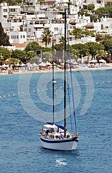Seascape with anchored sailboat off the beach