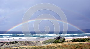 Seascape with beautiful multicoloured rainbow over the sea