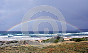 Seascape with beautiful multicoloured rainbow over the sea