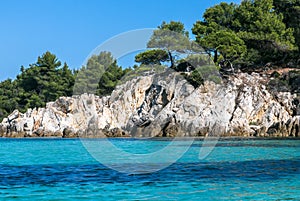 Seascape with beautiful turquoise water, blue sky, rocks and forest.