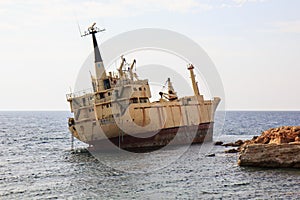 Seascape: boat EDRO III shipwrecked near the rocky shore at the sunset. Mediterranean, near Paphos. Cyprus