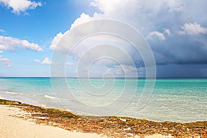 Seascape - bright azure Caribbean Sea, cumulus clouds and a rainbow. Picture taken in Cuba