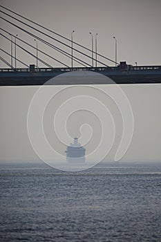 Seascape with cable-stayed bridge and a receding ship. Neva Bay