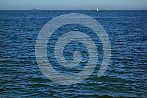 Seascape with cargo ships and a sailing boat