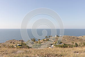 Seascape with cliffs and fishermen's house on the shore.