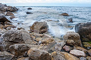 Seascape of the Crimean coast. Waves break into beautiful splashes against rocks.