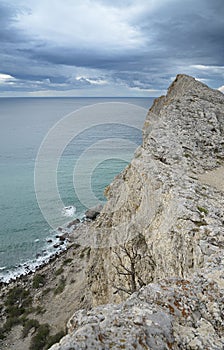 Seascape at edge high rocky cliff Cloudy sky.