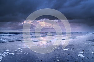 Seascape landscape during sunset with dramatic sky and dark clouds over the North Sea