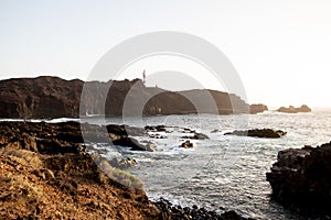 seascape with mountains and rocks, long exposure and waves that become foam. Image for black and white backgrounds. Tenerife