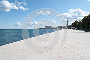 Seascape with a pebble beach and a view of the port city. architectural and natural details of the city