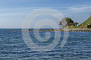 Seascape of pier for fishing in the Black Sea with larus, small house and tree at coast, ancient city Nessebar