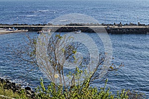 Seascape of pier for fishing boat with coastal road in the Black Sea and small beach near ancient city Nessebar