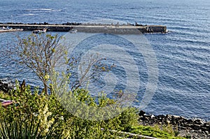 Seascape of pier for fishing boat with coastal road in the Black Sea and small beach near ancient city Nessebar