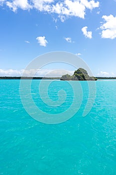 Seascape of Pines Island, new caledonia: turquoise lagoon, typical rocks, blue sky