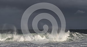 Seascape. Powerful ocean wave on the surface of the ocean. Wave breaks on a shallow bank. Stormy weather, stormy clouds sky