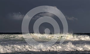 Seascape. Powerful ocean wave on the surface of the ocean. Wave breaks on a shallow bank. Stormy weather, stormy clouds sky