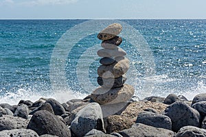 Seascape. Pyramid of stones on a rocky shore against the sea