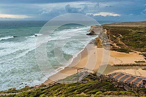 Seascape of Ribeira d`Ilhas beach, its wooden walkways and trails on the hill, Ericeira PORTUGAL