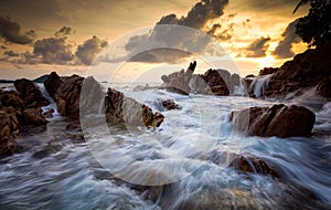 Seascape with rock in sunset scenery background