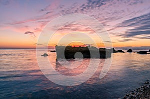 Seascape with rocks and nice sky in the summer season during the sunset