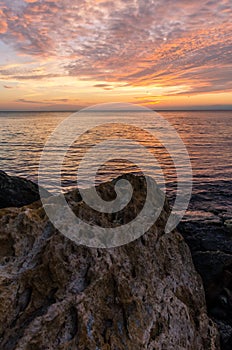 Seascape with rocks and nice sky in the summer season during the sunset