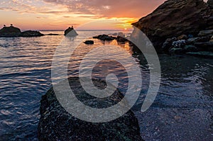 Seascape with rocks and nice sky in the summer season during the sunset