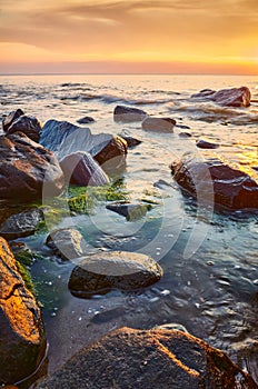 Seascape with rocks in water at sunset