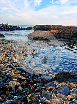 Seascape with rocky shallows and cloudy sky