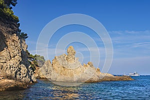 Seascape with a rocky shore in a clear sunny day. Large rocks in the sea near the coastline. Nature of Costa Brava, Spain.