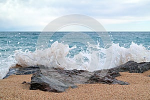 Seascape with rocky stones and splashes in the foreground