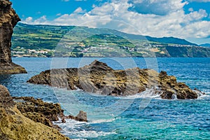 Rocks in turquoise sea with coastline of SÃ£o Miguel island in the background, Azores PORTUGAL photo