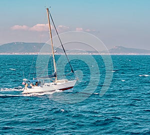 Seascape with sailboat the background of the blue sky.