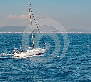 Seascape with sailboat the background of the blue sky.