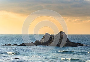 Seascape of the Sakurai Futamigaura`s Couple Stones protected by a sacred shimenawa rope at sunset.